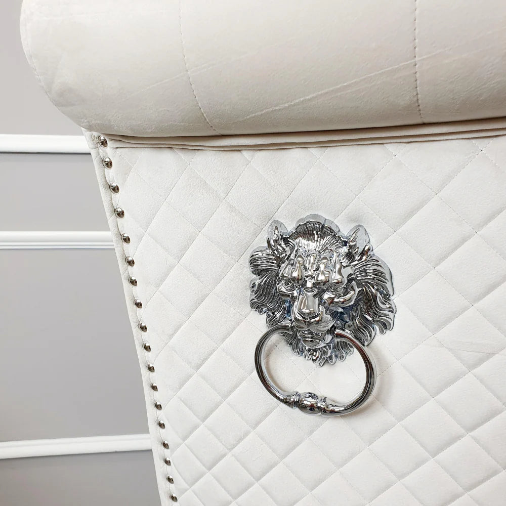 Cream upholstered chair with a decorative lion head handle