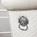 Cream upholstered chair with a decorative lion head handle