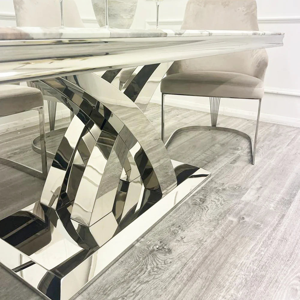 marble Dining table with modern, reflective metal legs in a room with chairs. first class interiors